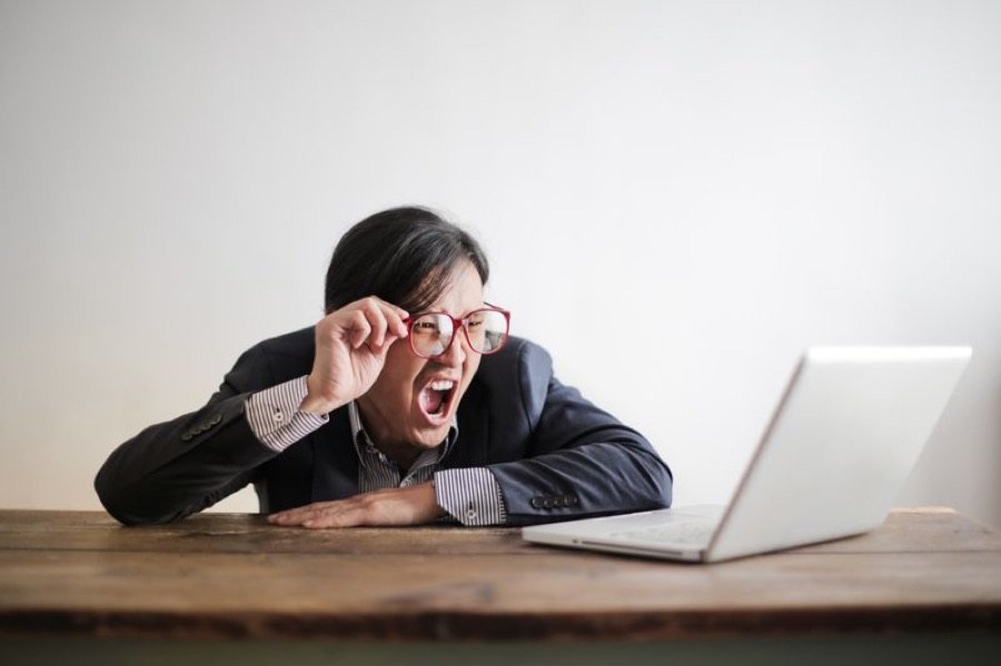 Persona frustrada frente a un computador lento